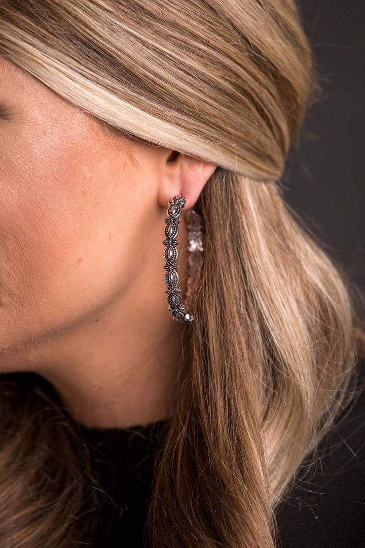 Burnished silver scalloped hoop earring from West & Co., featuring a 2-inch diameter with a textured, elegant design.