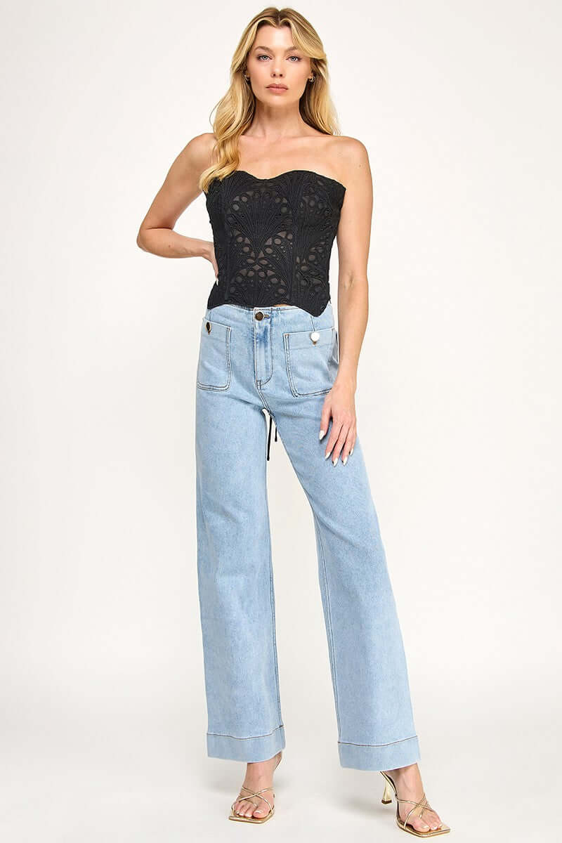 Cutwork corset top from The Vintage Shop featuring intricate lace detailing and a fitted design, displayed on a hanger.