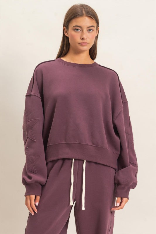 Plum star sleeve sweatshirt by HYFVE featuring oversized fit, cozy fabric, and star details on the sleeves.