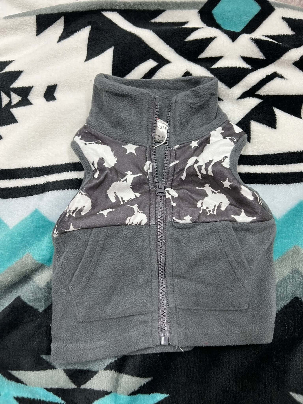 Shea Baby kids' Bronc Fleece Vest in cozy, soft fleece fabric, styled with a front zipper and ribbed hem for warmth.