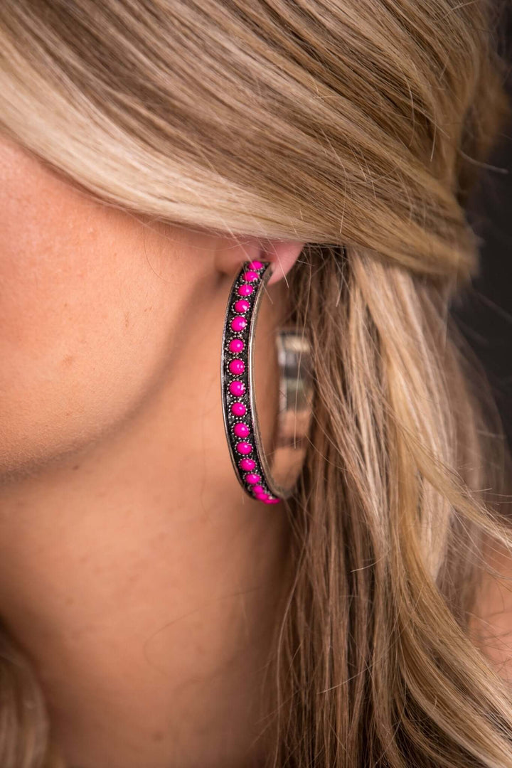 Burnished silver and pink hoop earring from West & Co. featuring a polished finish and vibrant color contrast.