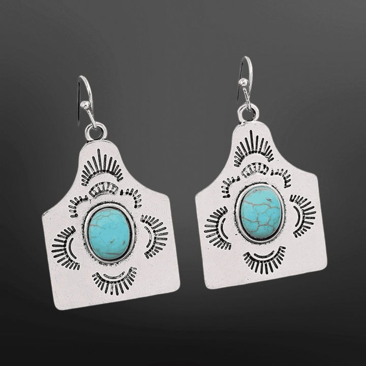Silver Western earrings with faux turquoise cow tag design by Westrian International, featuring a rustic cowboy style.