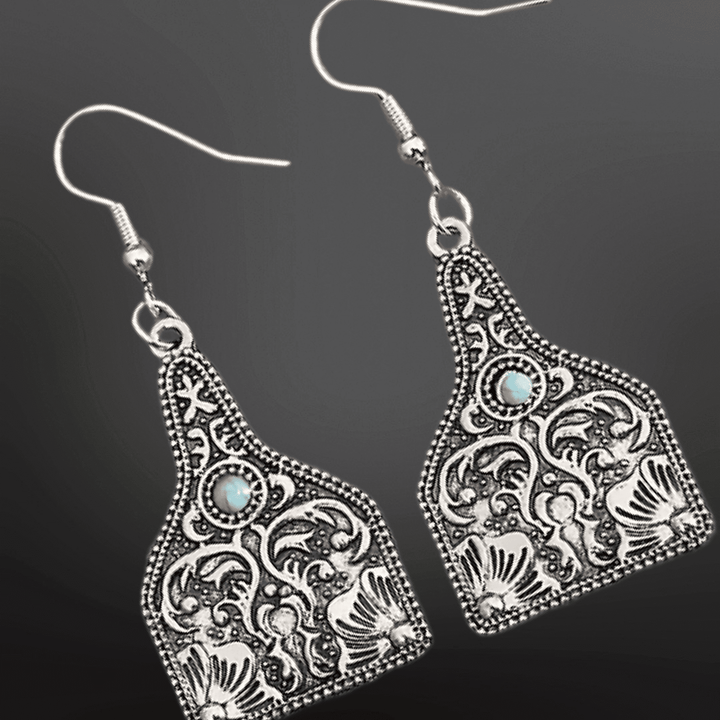 Western Faux Turquoise Cow Tag Earrings by Westrian International, featuring cow-shaped metal tags with turquoise accents.