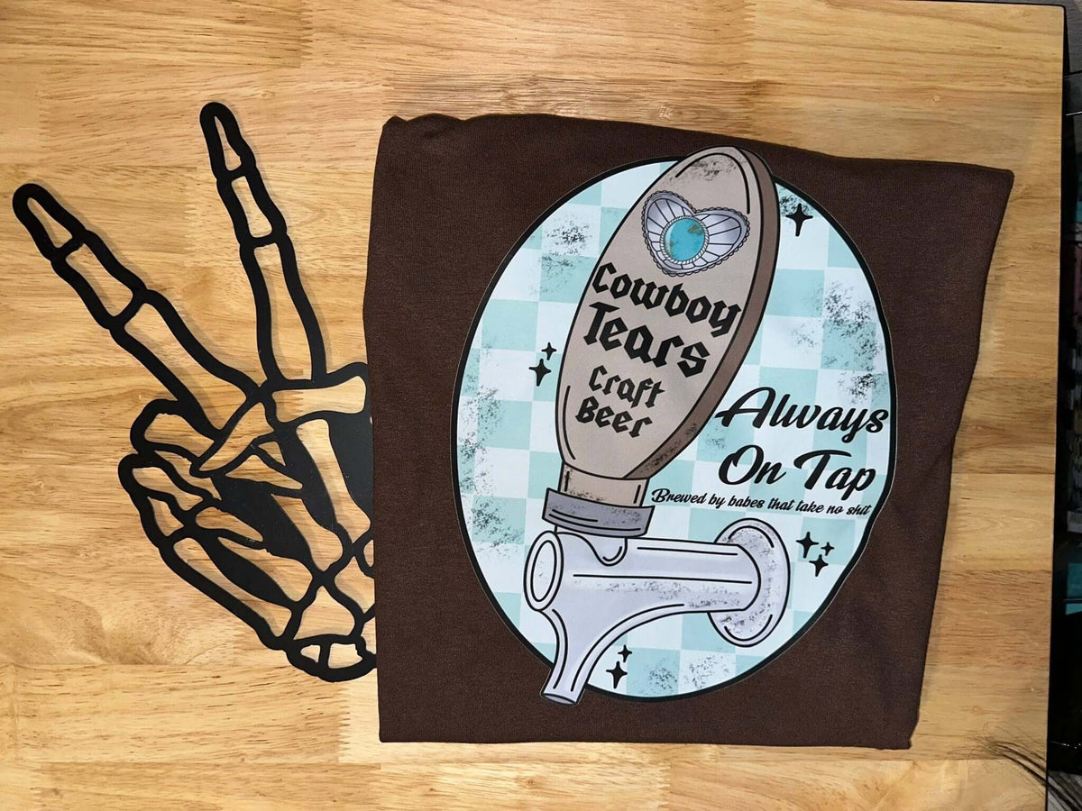 Western graphic T-shirt featuring cowboy tears design from Bar Tabs Wholesale, casual fit, black fabric with colorful print.