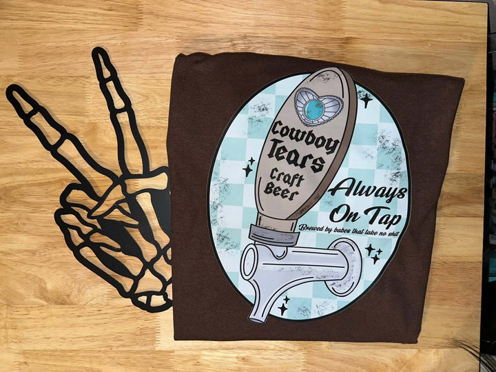 Western graphic T-shirt featuring cowboy tears design from Bar Tabs Wholesale, casual fit, black fabric with colorful print.