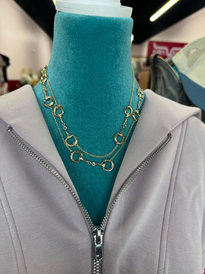 Long golden link necklace by Cowgirl Charm featuring chunky interconnected chain links on a neutral background.