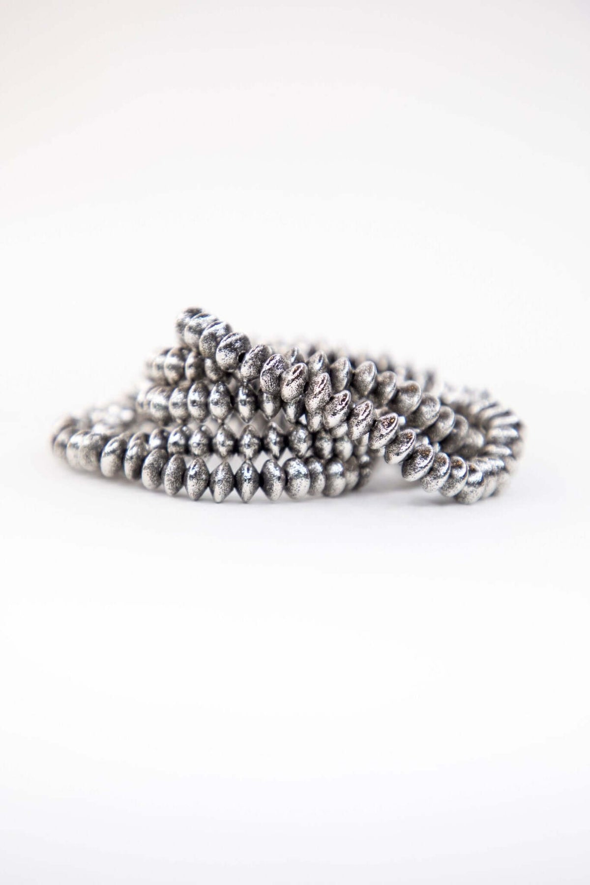 Gold-plated burnished 5-disc bead stretch bracelet from West & Co., stylish jewelry accessory with a sleek, shiny finish.