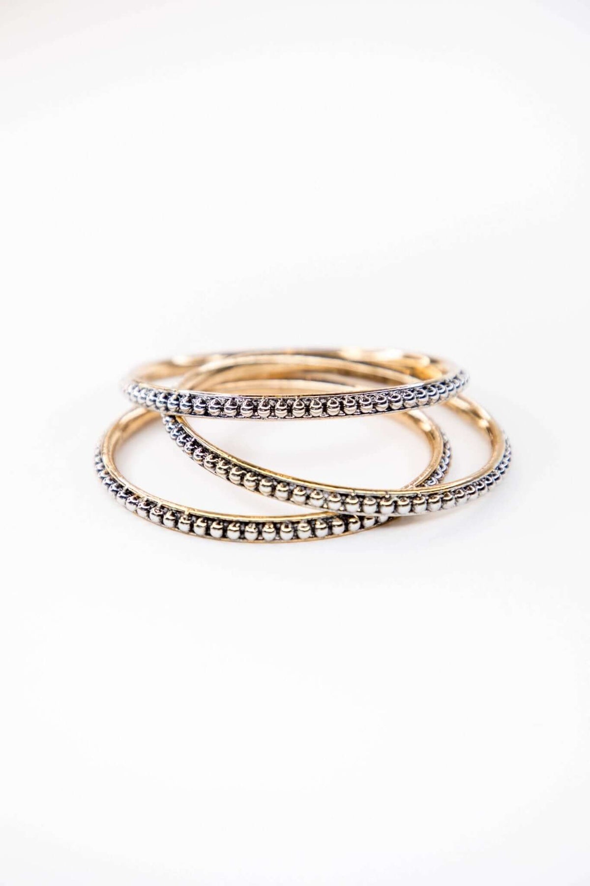 West & Co. 18K plated dotted bangle jewelry set featuring multiple slim bangles with dotted details.