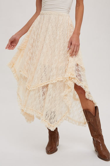 Cream lace ruffle midi skirt by blueivy featuring asymmetrical hem and boho western style, shown flowing in a natural outdoor setting.