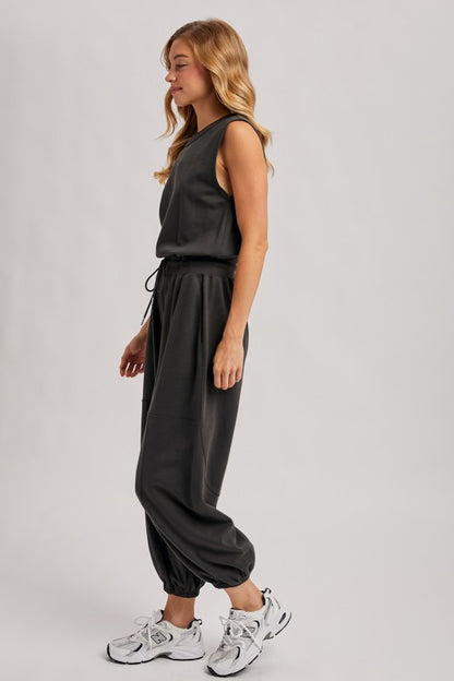 Washed black sleeveless jogger jumpsuit with relaxed fit and drawstring waist, featuring a skirt-like design from blueivy.
