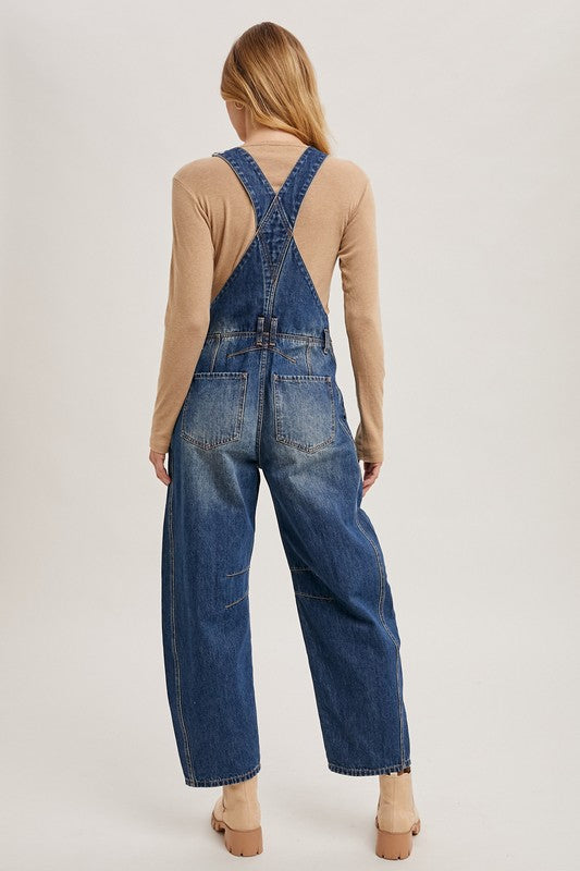 Women’s blue denim barrel overalls with relaxed wide-leg fit, bib style, by blueivy, shown hanging on a rack.