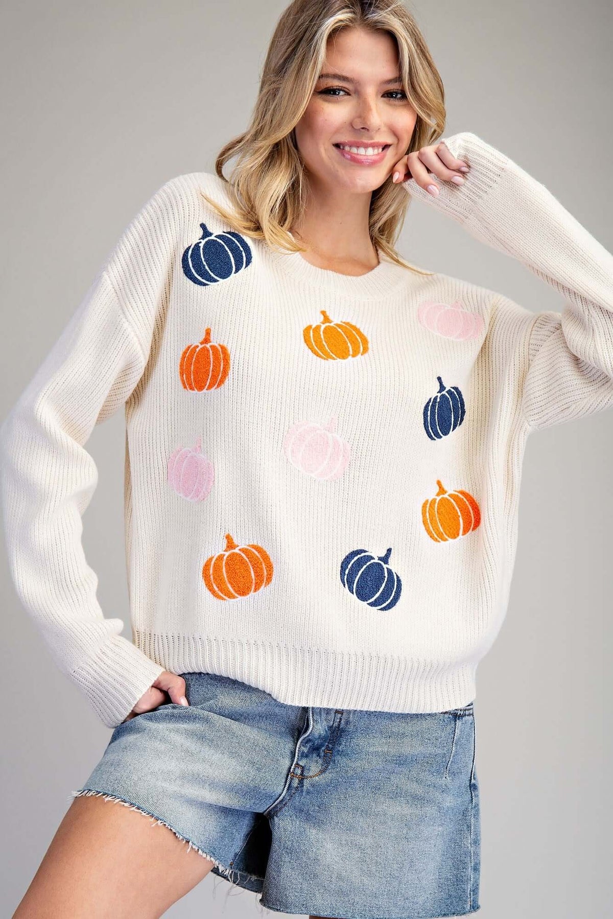 Ivory knit sweater with embroidered fall pumpkin design by ee:some, cozy sweater perfect for autumn fashion.