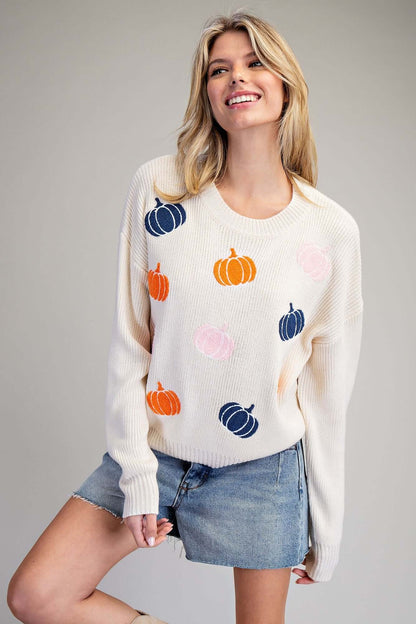 Ivory knit sweater with embroidered fall pumpkin design by ee:some, featuring cozy, textured fabric perfect for autumn.