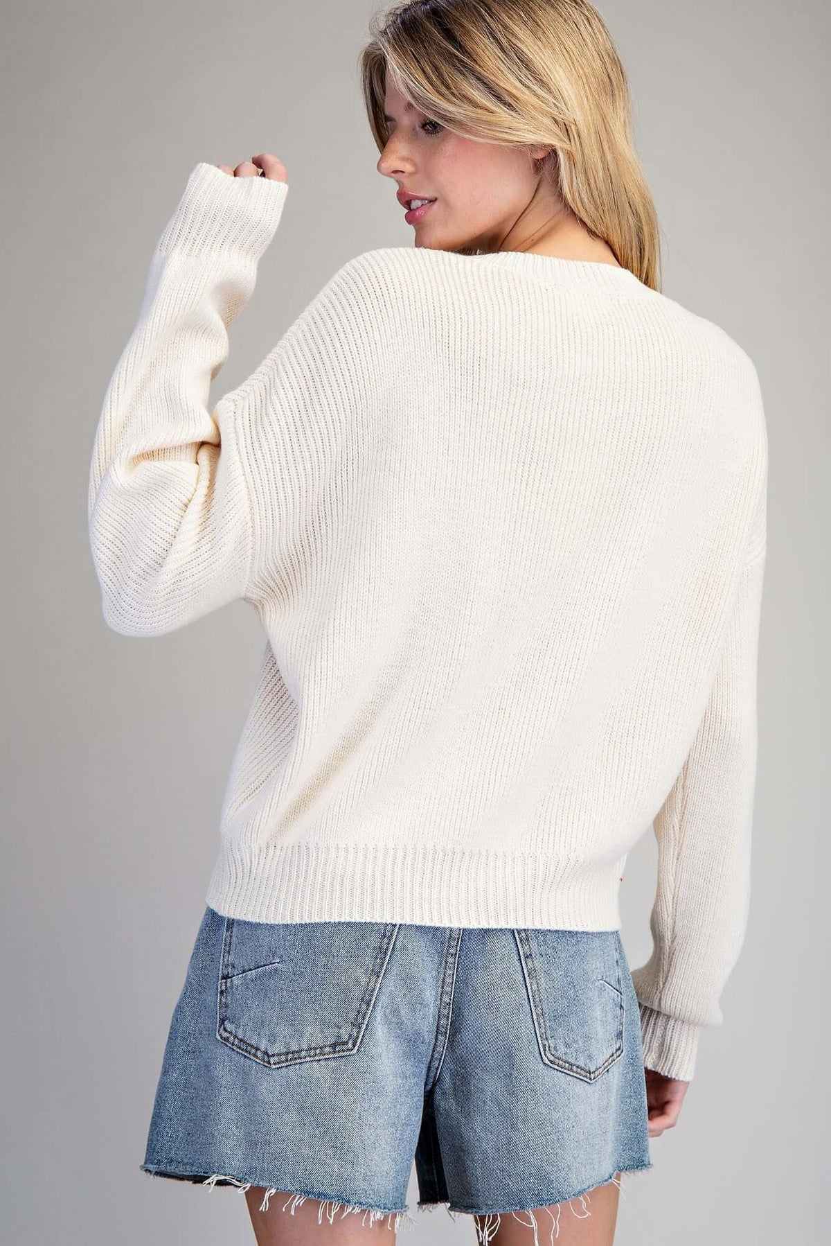 Ivory knit sweater with embroidered fall pumpkin design by ee:some, featuring a cozy, autumn-inspired look.