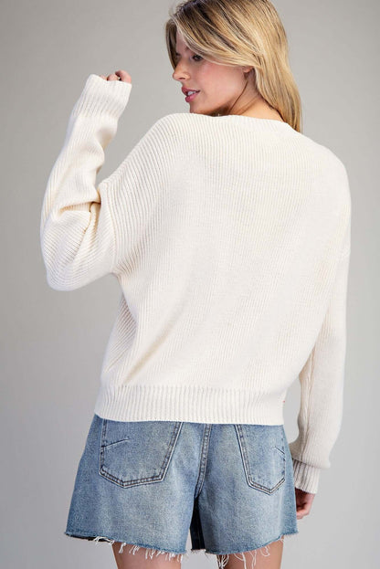 Ivory knit sweater with embroidered fall pumpkin design by ee:some, featuring a cozy, autumn-inspired look.