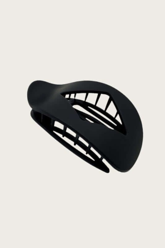 Leto Accessories matte claw clip holding hair, stylish hair accessory in a neutral matte finish.
