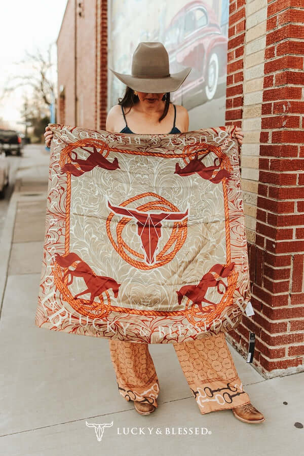 Beige cow skull printed wild rag from Lucky & Blessed, traditional western accessory with intricate tooled design.