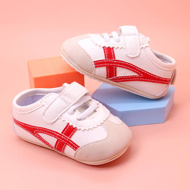 Off white infant tennis shoes with red design