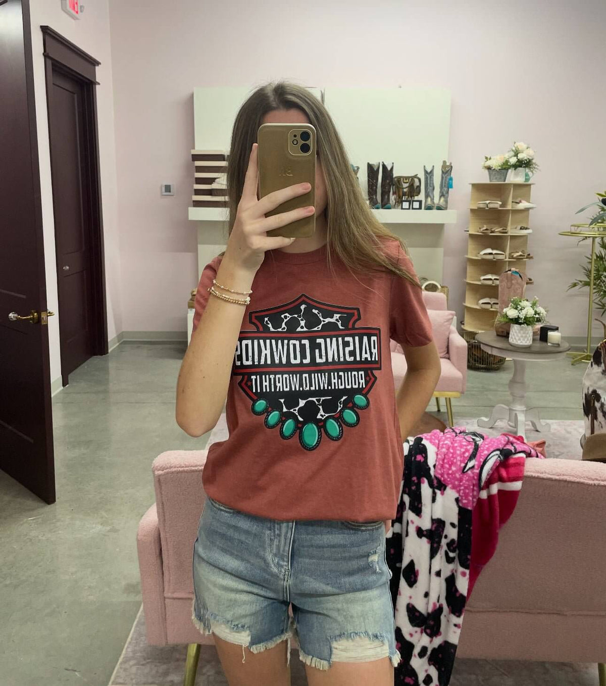 Vintage rust-colored Raising Cowboys Western graphic T-shirt by Lucky and Blessed Life featuring cowboy illustrations and retro style.
