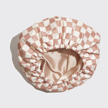 KITSCH satin-lined flexi shower cap with terracotta checker pattern, waterproof design, and adjustable fit for hair protection.