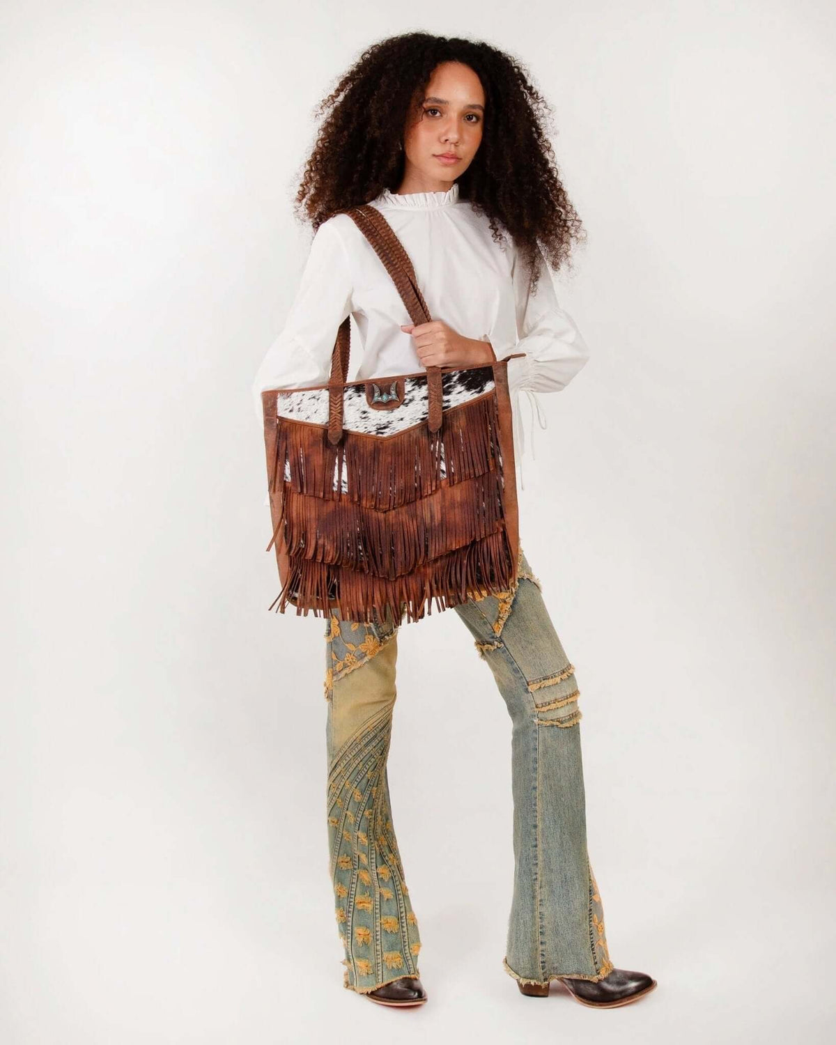 Loyal West Myra bag with fringe and cowhide design, large purse featuring natural textures and stylish detailing.