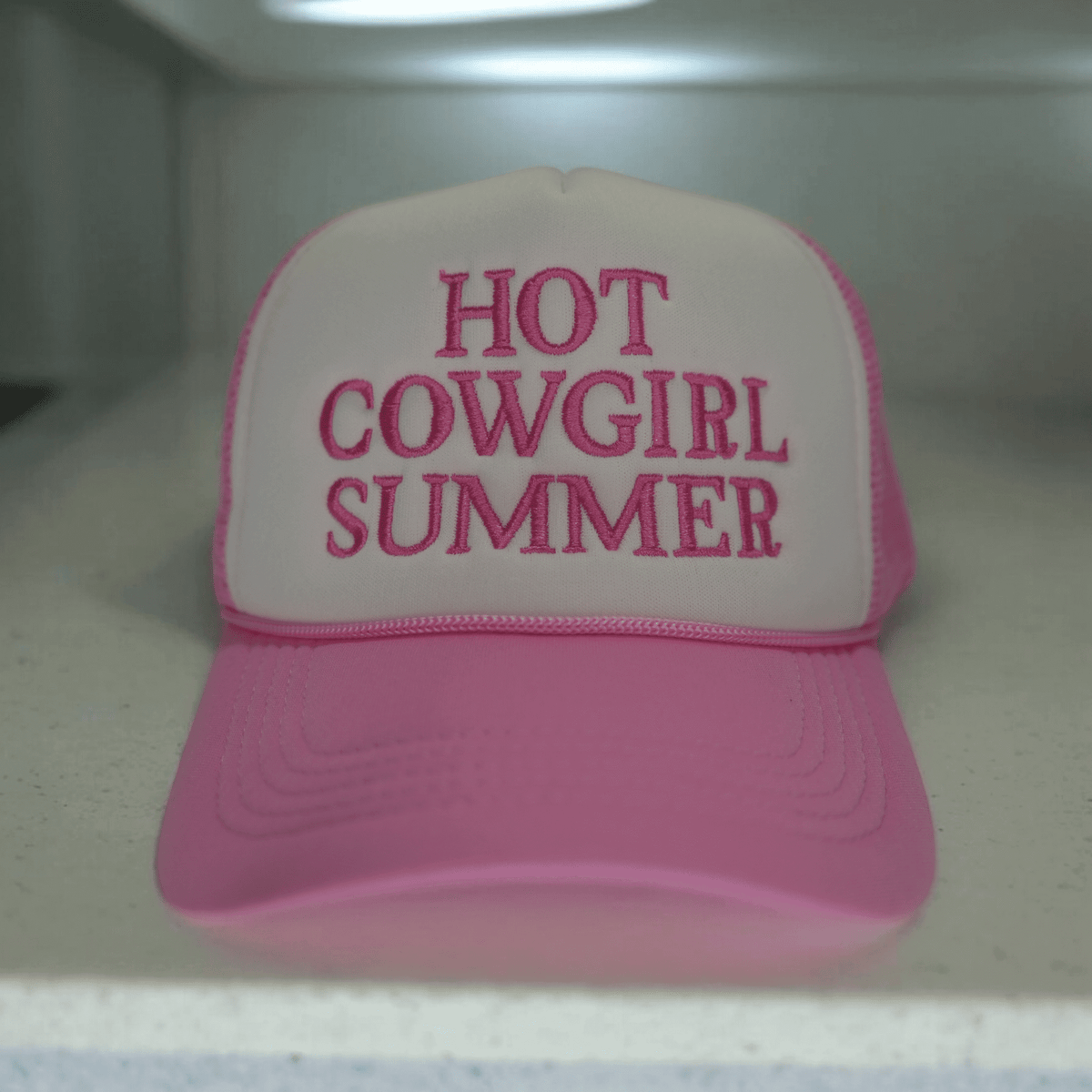 Light pink cowgirl summer trucker hat with embroidered design by Wilde Roots, stylish accessories for warm-weather outfits.