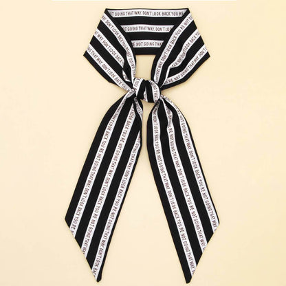 ACCITY Letter Floral Twilly Scarf styled as a hair ribbon and bag tie with vibrant floral and letter pattern.