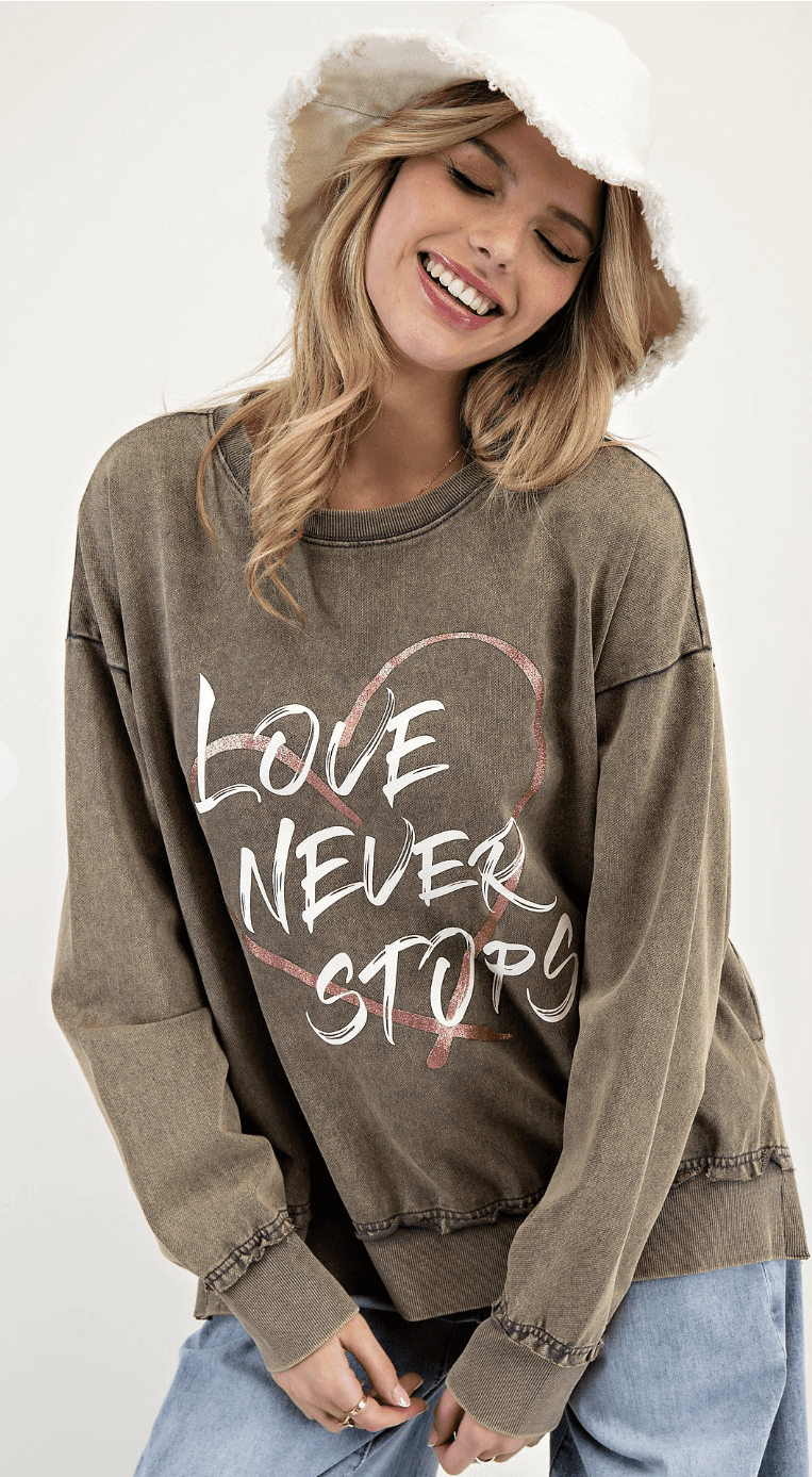 Easel Love Never Stops mineral washed graphic sweatshirt with inspirational text and casual style.