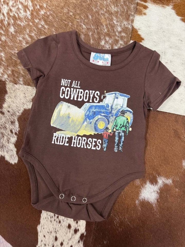 Shea Baby kids' "Not all cowboys ride horses" graphic onesie featuring a playful cowboy and horse illustration.