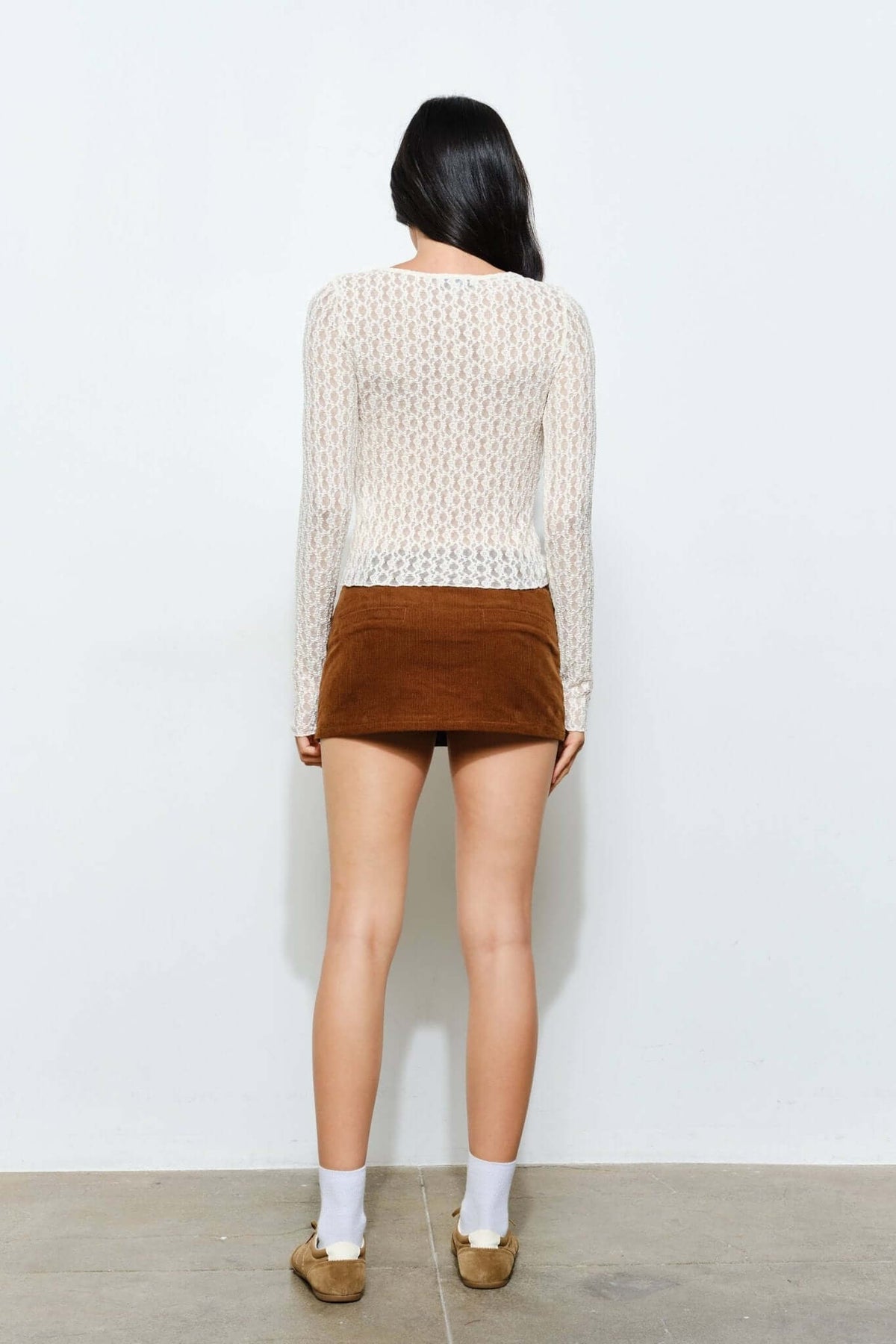 Light brown Peyton corduroy skort by Pretty Garbage, casual retro style, with front pleats and side pockets, worn with a white top.
