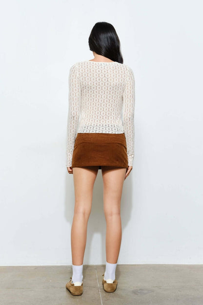 Light brown Peyton corduroy skort by Pretty Garbage, casual retro style, with front pleats and side pockets, worn with a white top.