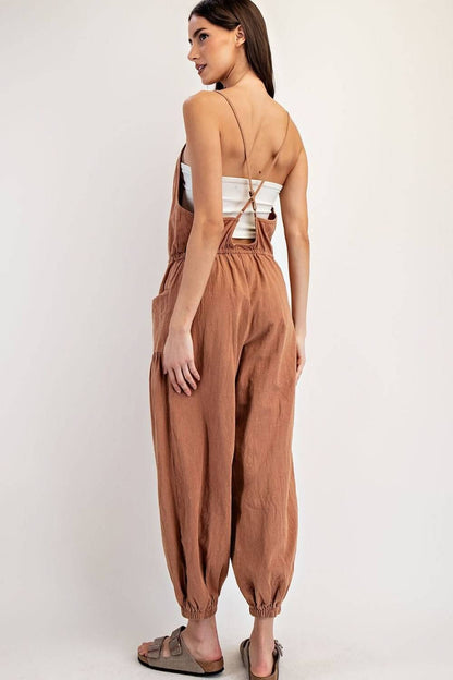 Ee:some pleated drawstring jogger jumpsuit with relaxed fit and tapered legs, made of lightweight fabric for casual comfort.