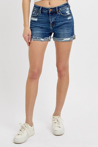 Women's Risen mid-rise distressed denim shorts with rolled cuffs, showcasing a casual, trendy style and frayed hem.