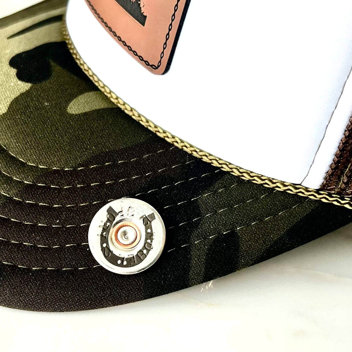 Bronze shotgun shell and horseshoe lapel pin by Brand Dandee, suitable as a stylish accessories or pin for clothing or hats.