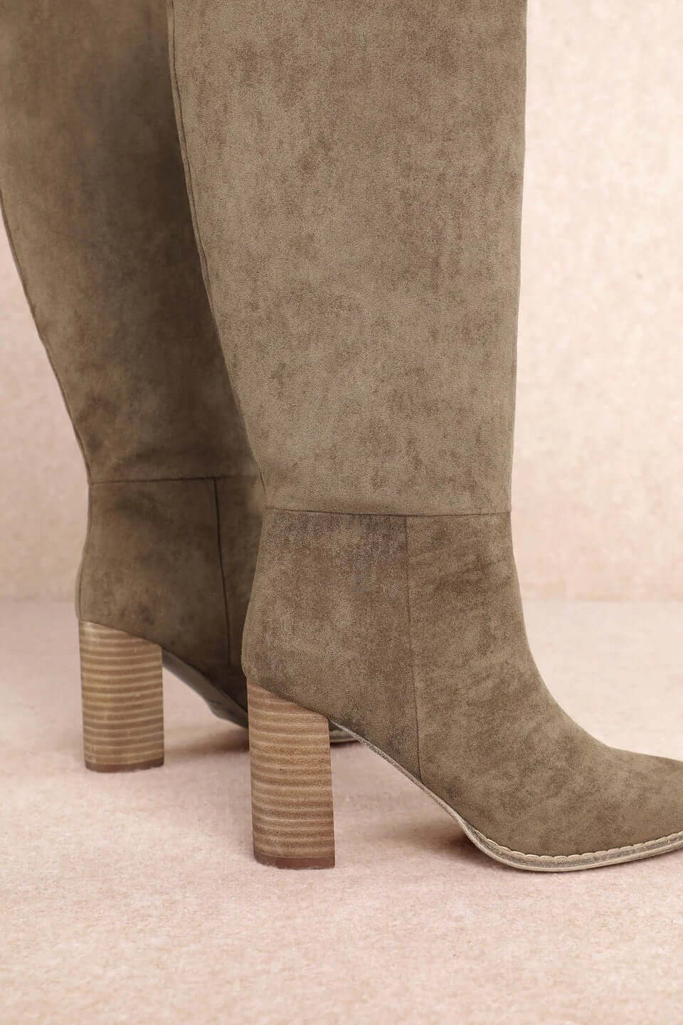 Taupe suede tall Western block heel boots by MI.MI, featuring pointed toes and stylish Western-inspired design.