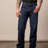 Kimes Ranch Watson men's dark wash relaxed bootcut jeans made of denim, shown hanging on a wooden background.