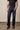 Kimes Ranch Watson men's dark wash relaxed bootcut jeans made of denim, shown hanging on a wooden background.