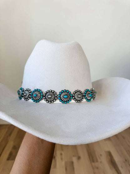 Western hat band with concho, stone accents, and longhorn steer design, featuring rustic boho style accessories.
