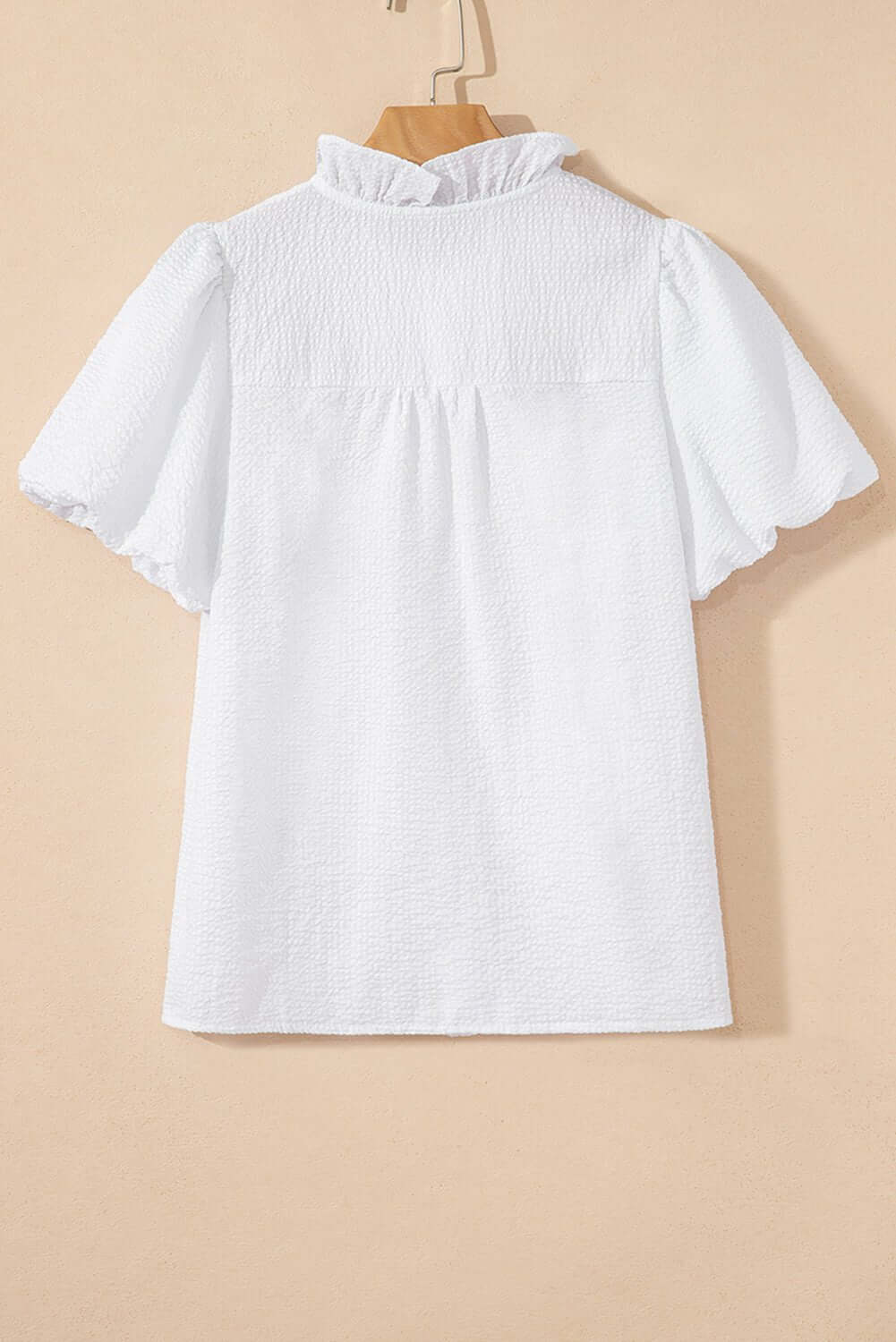 White ruffle-front puff sleeve blouse by Cowgirl Charm, featuring feminine ruffles and puffed sleeves, ideal for stylish tops or blouses.