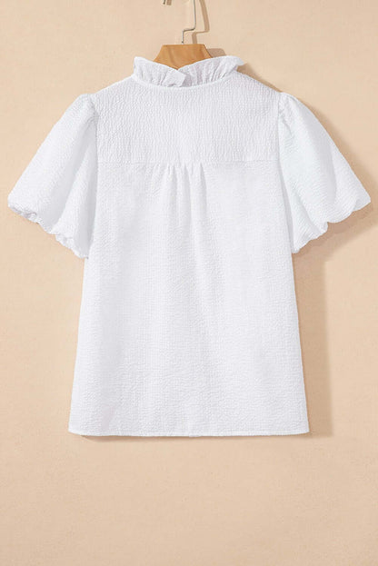 White ruffle-front puff sleeve blouse by Cowgirl Charm, featuring feminine ruffles and puffed sleeves, ideal for stylish tops or blouses.