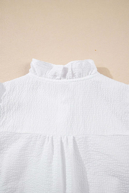 White ruffle front puff sleeve blouse by Cowgirl Charm, featuring feminine ruffles and puffed sleeves for a stylish look.