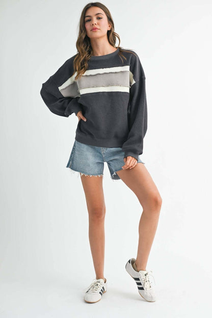 AEMI + CO Winnie graphic sweatshirt featuring a colorful Winnie the Pooh design on soft fabric, perfect for casual wear.