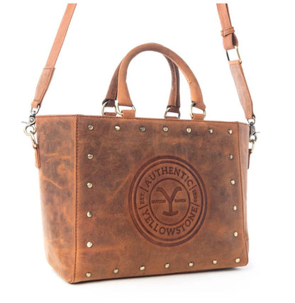 Yellowstone Legancy studded leather tote bag by Cowgirl Charm, featuring a spacious design with metal stud accents and sturdy handles.